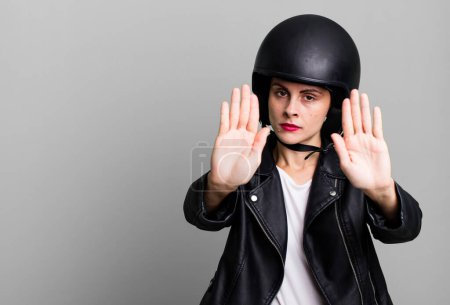 Foto de Young adult pretty woman. motorbike rider with leather jacket and helmet - Imagen libre de derechos