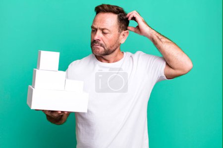 Photo for Middle age man smiling happily and daydreaming or doubting. blank packages concept - Royalty Free Image