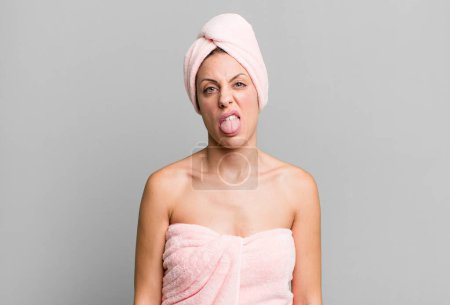 Photo for Pretty blonde woman feeling disgusted and irritated and tongue out. bathrobe and beauty concept - Royalty Free Image