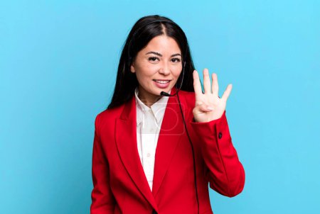 Photo for Hispanic pretty woman smiling and looking friendly, showing number four. telemarketing concept - Royalty Free Image