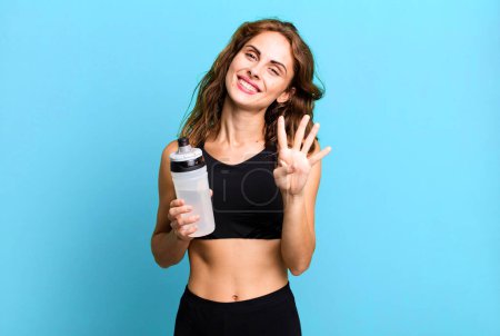 Foto de Mujer bonita hispana sonriendo y luciendo amigable, mostrando el número cuatro. concepto de fitness y ejercicio - Imagen libre de derechos