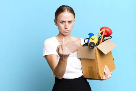 Foto de Caucasian pretty woman feeling angry, annoyed, rebellious and aggressive with a tool box. repair home concept - Imagen libre de derechos