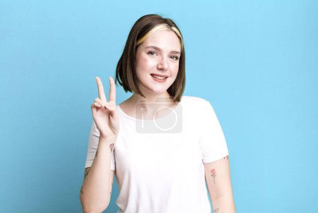 Foto de Joven bonita mujer sonriendo y buscando amigable, mostrando el número dos - Imagen libre de derechos