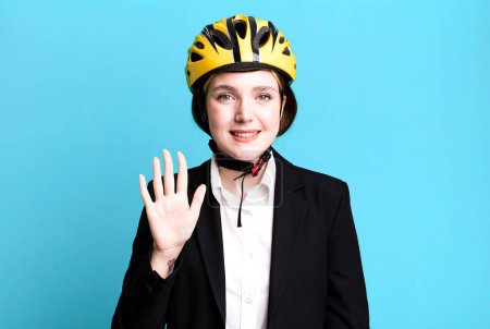 Foto de Joven bonita mujer sonriendo y buscando amigable, mostrando el número cinco. concepto de bicicleta y mujer de negocios - Imagen libre de derechos
