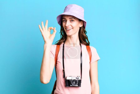 Photo for Young pretty woman feeling happy, showing approval with okay gesture. tourist concept - Royalty Free Image