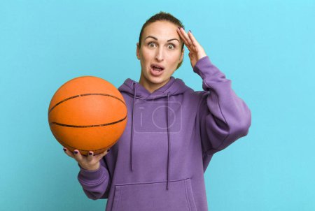 Photo for Young pretty woman looking happy, astonished and surprised. basketball concept - Royalty Free Image