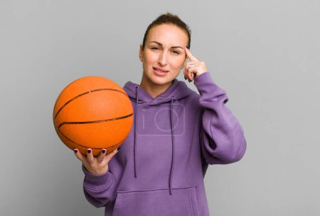 Foto de Joven bonita mujer sintiéndose confundido y perplejo, mostrando que está loco. concepto de baloncesto - Imagen libre de derechos