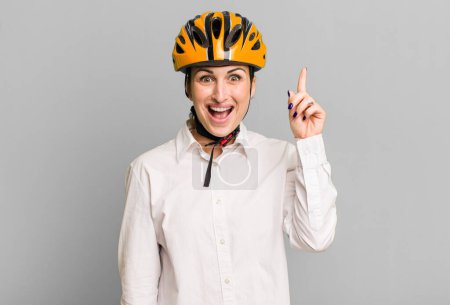 Photo for Young pretty woman feeling like a happy and excited genius after realizing an idea. business and bike concept - Royalty Free Image