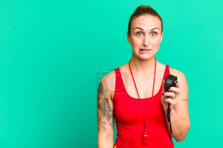 Photo for Young pretty woman looking puzzled and confused. swimm coach and stopwatch - Royalty Free Image