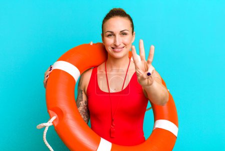 Photo for Young pretty woman smiling and looking friendly, showing number three. summer and lifeguard concept - Royalty Free Image