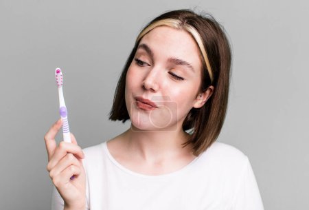 Photo for Young pretty woman using a toothbrush - Royalty Free Image