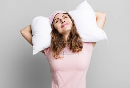 Photo for Hispanic pretty young woman wearing pajamas night wear and a pillow - Royalty Free Image