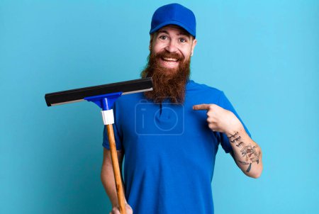 Téléchargez les photos : Jeune adulte cheveux roux barbu homme cool. concept de laveuse de fenêtres - en image libre de droit