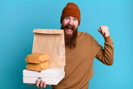 Téléchargez les photos : Longue barbe et cheveux roux homme cool. livraison et emporter concept de nourriture - en image libre de droit