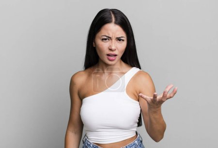 Foto de Mujer latina bonita mirando enojado, molesto y frustrado gritando wtf o lo que está mal con usted - Imagen libre de derechos