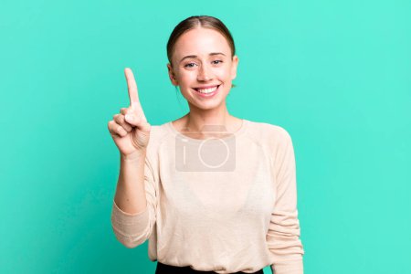 Photo for Smiling and looking friendly, showing number one or first with hand forward, counting down - Royalty Free Image