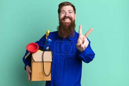 Photo for Long beard man smiling and looking happy, gesturing victory or peace. repairman with toolbox concept - Royalty Free Image