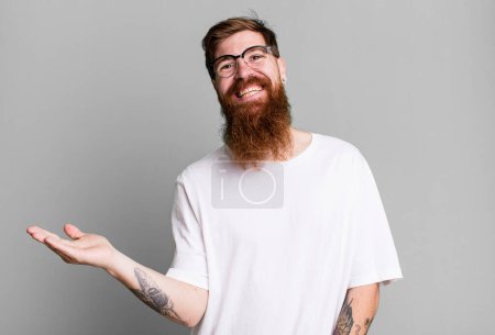 Téléchargez les photos : Longue barbe et cheveux roux homme souriant joyeusement, se sentant heureux et montrant un concept - en image libre de droit