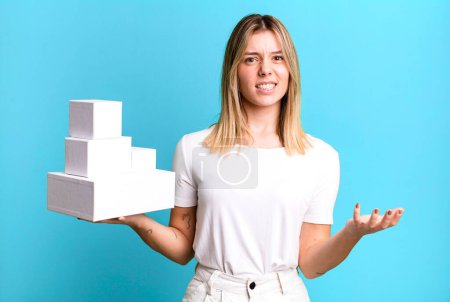 Foto de Joven bonita mujer mirando enojado, molesto y frustrado. concepto de cajas blancas en blanco - Imagen libre de derechos