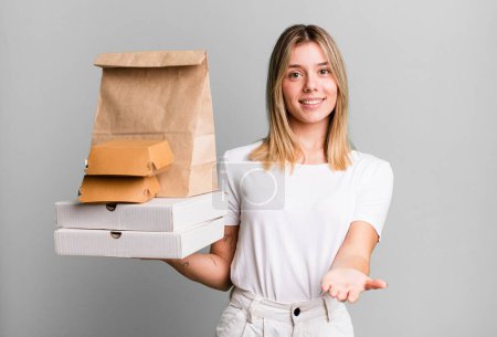 Photo for Young pretty woman smiling happily with friendly and  offering and showing a concept. delivery and take away food concept - Royalty Free Image