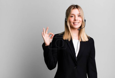 Photo for Young pretty woman feeling happy, showing approval with okay gesture. telemarketer concept - Royalty Free Image