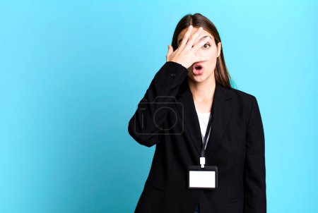Photo for Young pretty woman looking shocked, scared or terrified, covering face with hand. businesswoman concept - Royalty Free Image
