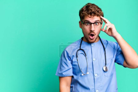 Photo for Young adult caucasian man looking surprised, realizing a new thought, idea or concept. nurse concept - Royalty Free Image