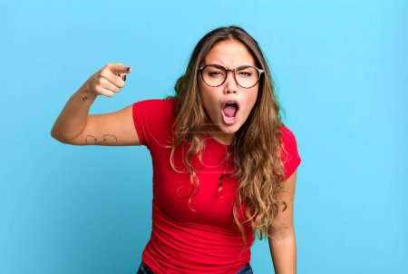 Photo for Young pretty woman pointing at camera with an angry aggressive expression looking like a furious, crazy boss - Royalty Free Image