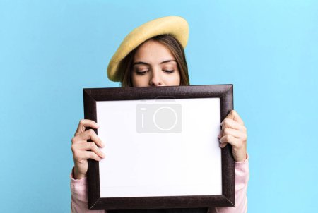 Photo for Young pretty woman with an empty picture frame copy space - Royalty Free Image