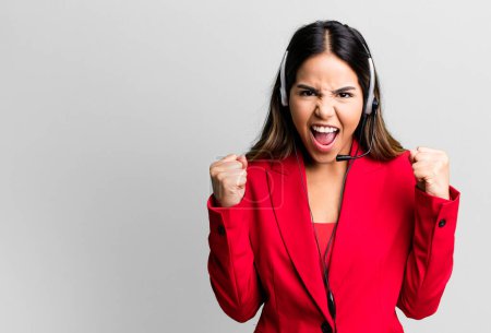 Photo for Hispanic pretty woman shouting aggressively with an angry expression. telemarketing concept - Royalty Free Image