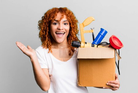 Photo for Red hair pretty woman feeling happy and astonished at something unbelievable. housekeeper and toolbox concept - Royalty Free Image