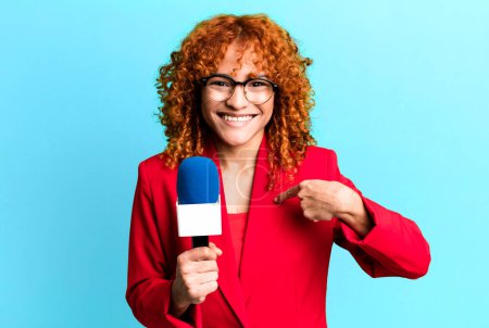 Téléchargez les photos : Cheveux roux jolie femme se sentant heureux et pointant vers soi-même avec un excité. concept de journaliste et présentateur - en image libre de droit