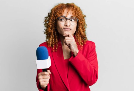 Photo for Red hair pretty woman thinking, feeling doubtful and confused. journalist and presenter concept - Royalty Free Image