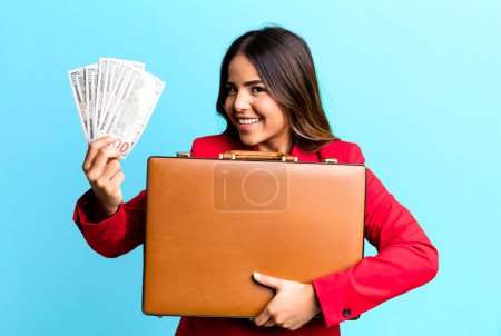 Photo for Hispanic pretty young adult woman with a suit case with banknotes - Royalty Free Image