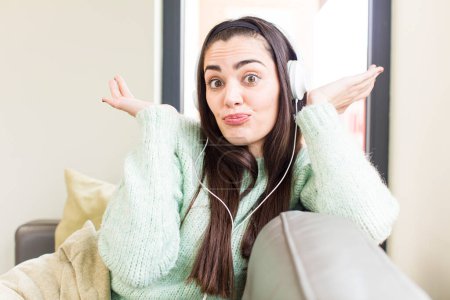 Foto de Bonita mujer joven escuchar música con auriculares. casa de diseño de interiores - Imagen libre de derechos