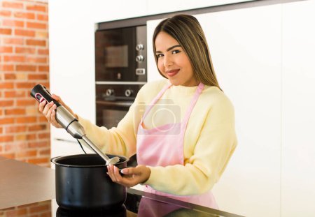 Photo for Pretty latin chef woman cooking at home - Royalty Free Image