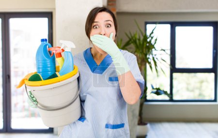 Photo for Young pretty woman covering mouth with hands with a shocked. housekeeper concept - Royalty Free Image