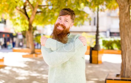 Photo for Red hair bearded man smiling cheerfully and celebrating, with fists clenched and arms crossed, feeling happy and positive - Royalty Free Image