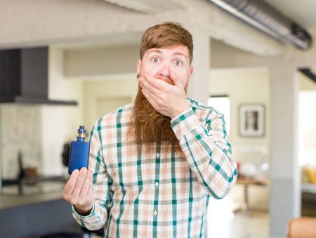 Foto de Hombre de pelo rojo que cubre la boca con una mano y expresión sorprendida o sorprendida con un pañal - Imagen libre de derechos