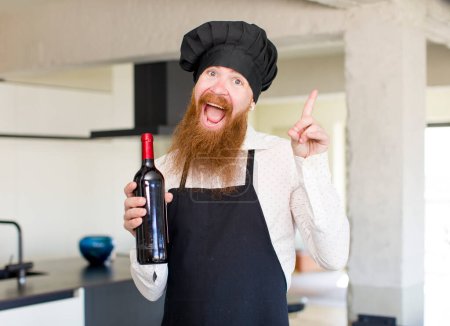 Photo for Red hair man feeling like a happy and excited genius after realizing an idea with a wine bottle. chef concept - Royalty Free Image