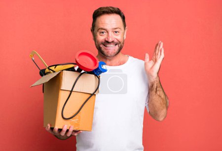 Foto de Hombre de mediana edad sentirse feliz, sorprendido de darse cuenta de una solución o idea. manitas con caja de herramientas - Imagen libre de derechos