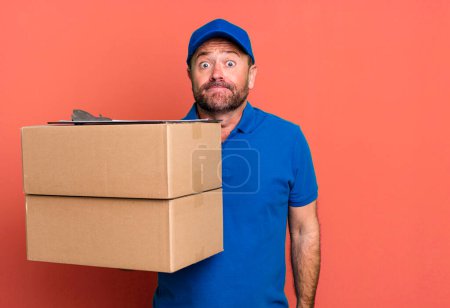 Photo for Middle age man shrugging, feeling confused and uncertain. paker delivery man. packer delivery man - Royalty Free Image