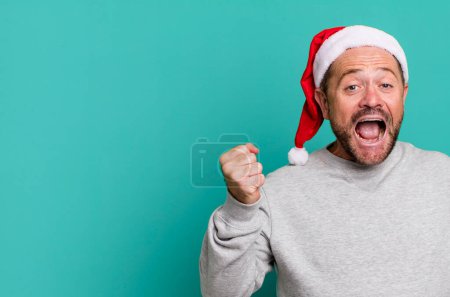 Téléchargez les photos : Homme d'âge moyen se sentir choqué, rire et célébrer le succès. concept de Noël - en image libre de droit