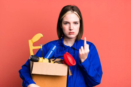Photo for Young pretty woman feeling angry, annoyed, rebellious and aggressive. housekeeper and toolbox concept - Royalty Free Image