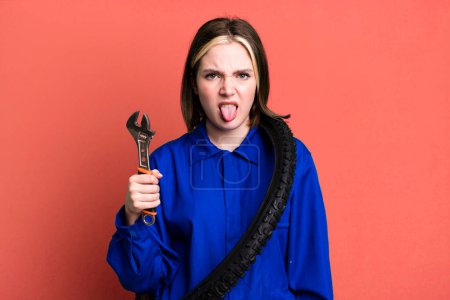 Photo for Young pretty woman feeling disgusted and irritated and tongue out. bike mechanic concept - Royalty Free Image