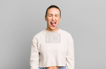 Foto de Joven bonita mujer con actitud alegre y rebelde, bromeando y sacando la lengua - Imagen libre de derechos