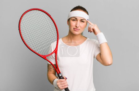 Téléchargez les photos : Jeune jolie femme se sentant confus et perplexe, montrant que vous êtes fou. concept de tennis - en image libre de droit