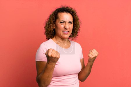 Photo for Middle age hispanic woman feeling provocative, aggressive and obscene, flipping the middle finger, with a rebellious attitude - Royalty Free Image