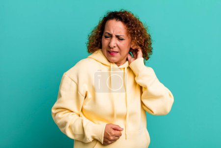 Photo for Middle age hispanic woman feeling stressed, frustrated and tired, rubbing painful neck, with a worried, troubled look - Royalty Free Image