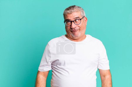 Téléchargez les photos : Homme âgé d'âge moyen regardant fou et drôle avec une expression stupide aux yeux croisés, plaisanter et s'amuser autour - en image libre de droit